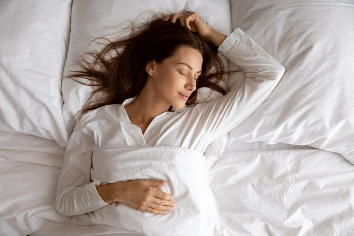 woman sleeping on her back in bed