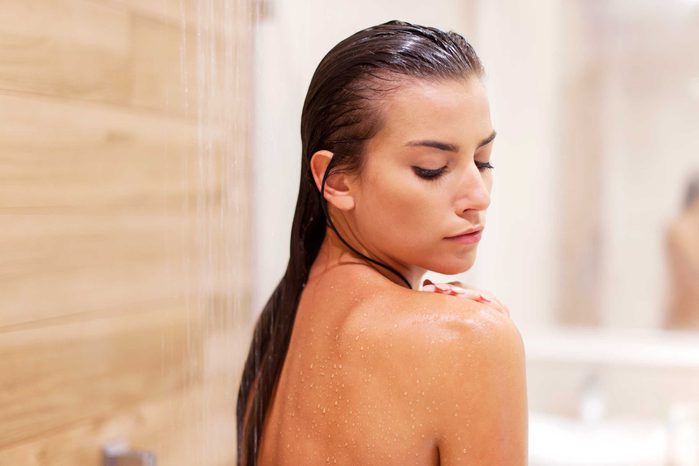 bathing dark-haired woman looking over her shoulder