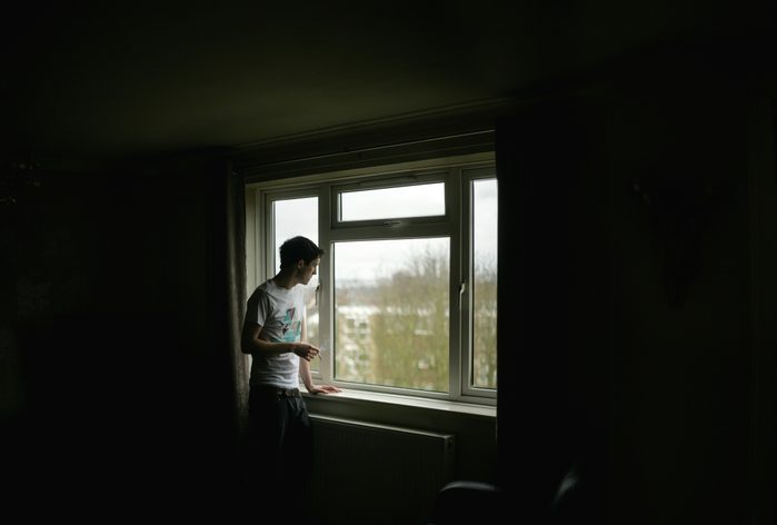 man looking out window