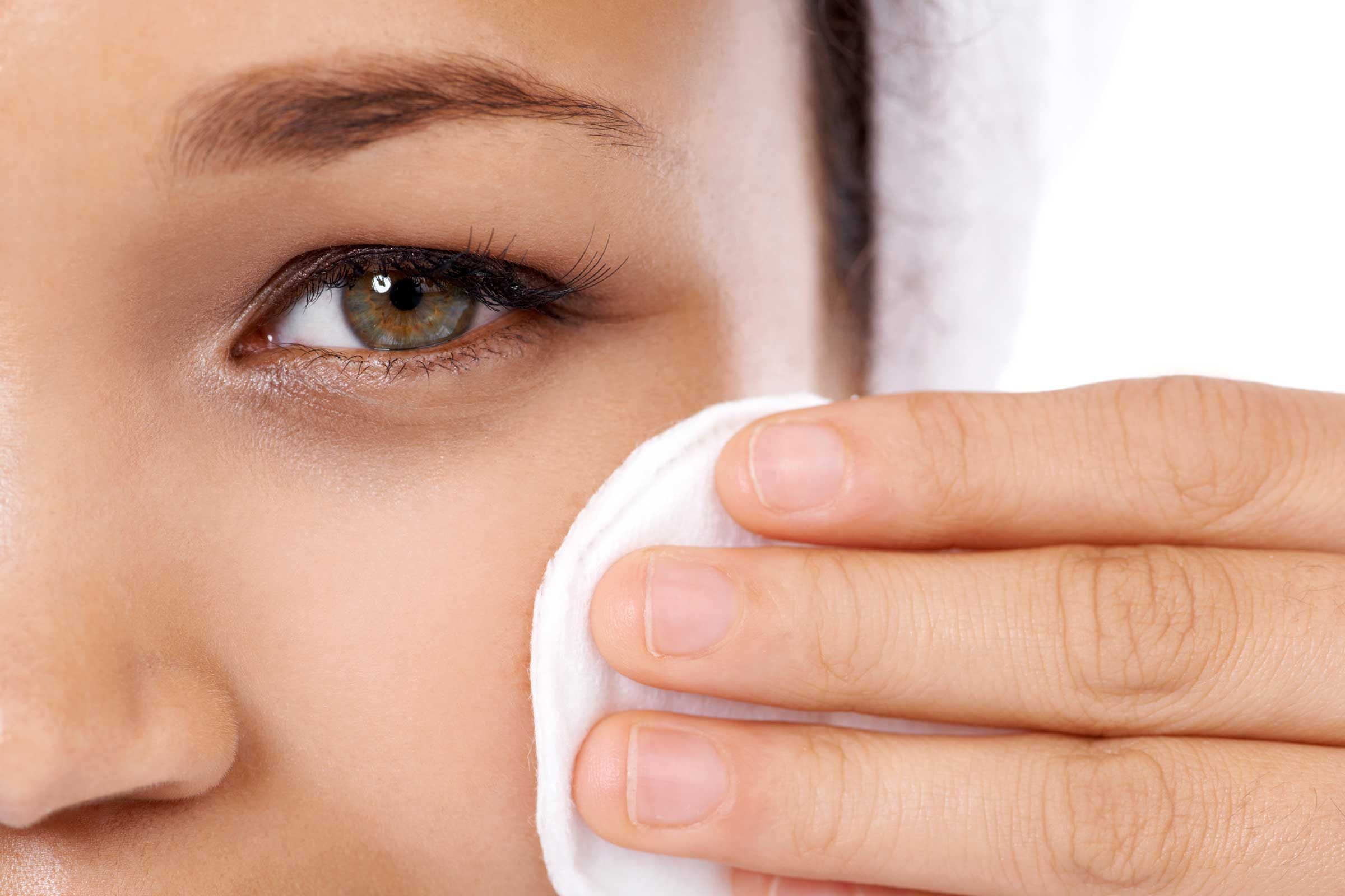 Woman holding a makeup removal pad.