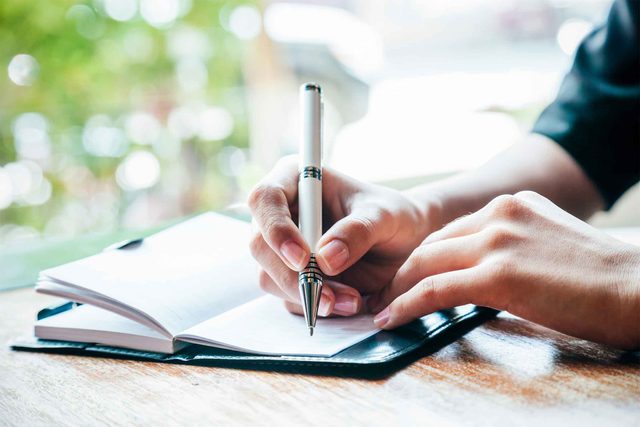 person writing in a journal