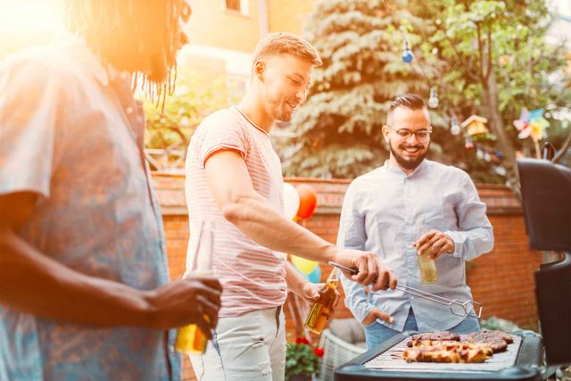 men standing around grill