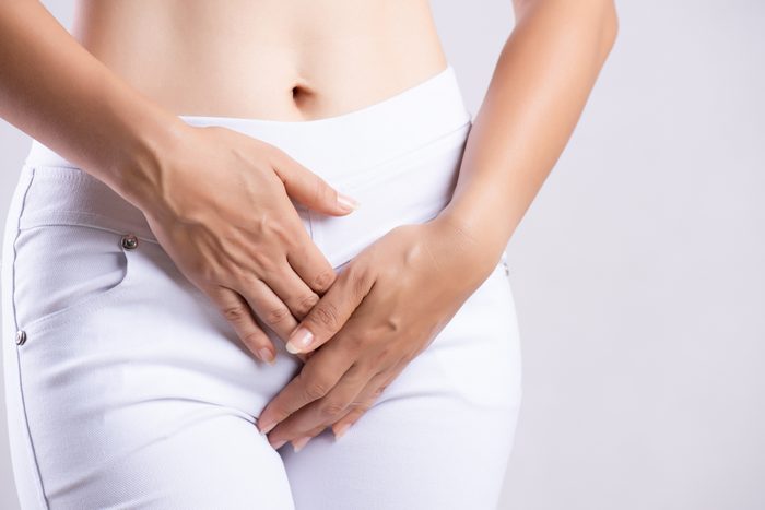 cropped shot of woman with hands between her legs