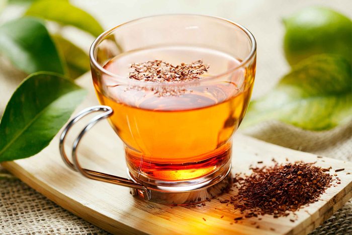 glass mug of tea next to pile of dried tea