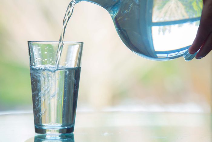 Water pouring from a pitcher into a glass.