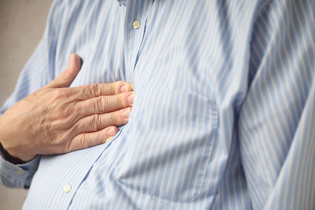 Man with hand over his chest.