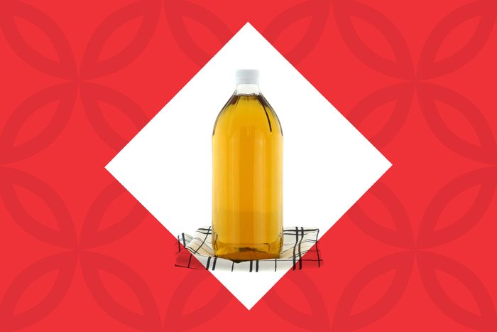 bottle of apple cider vinegar on a kitchen towel