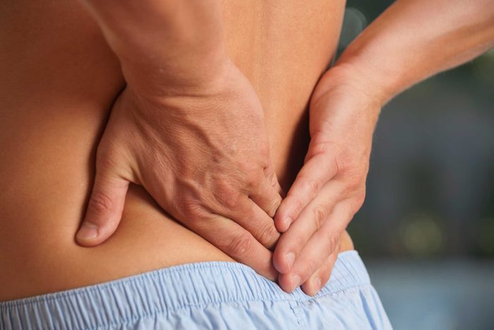 Man holding his back having sciatica pain.
