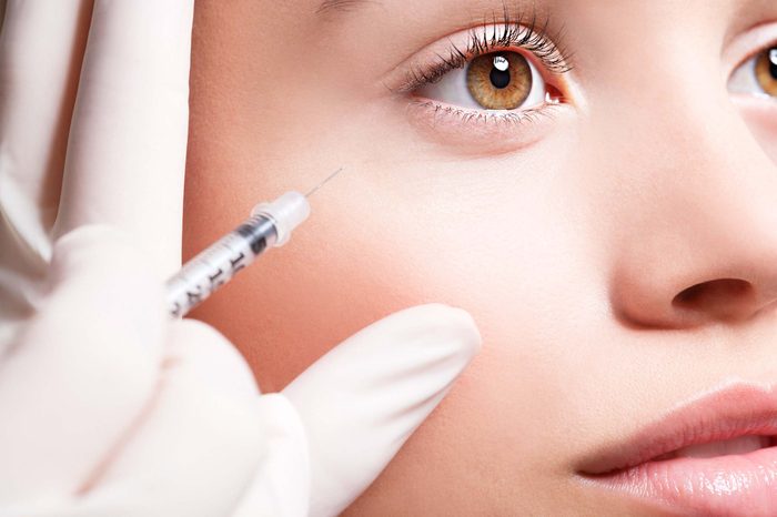 woman getting face injection or electrodessication
