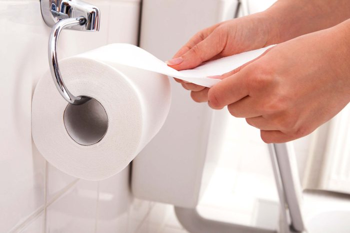 person grabbing toilet paper