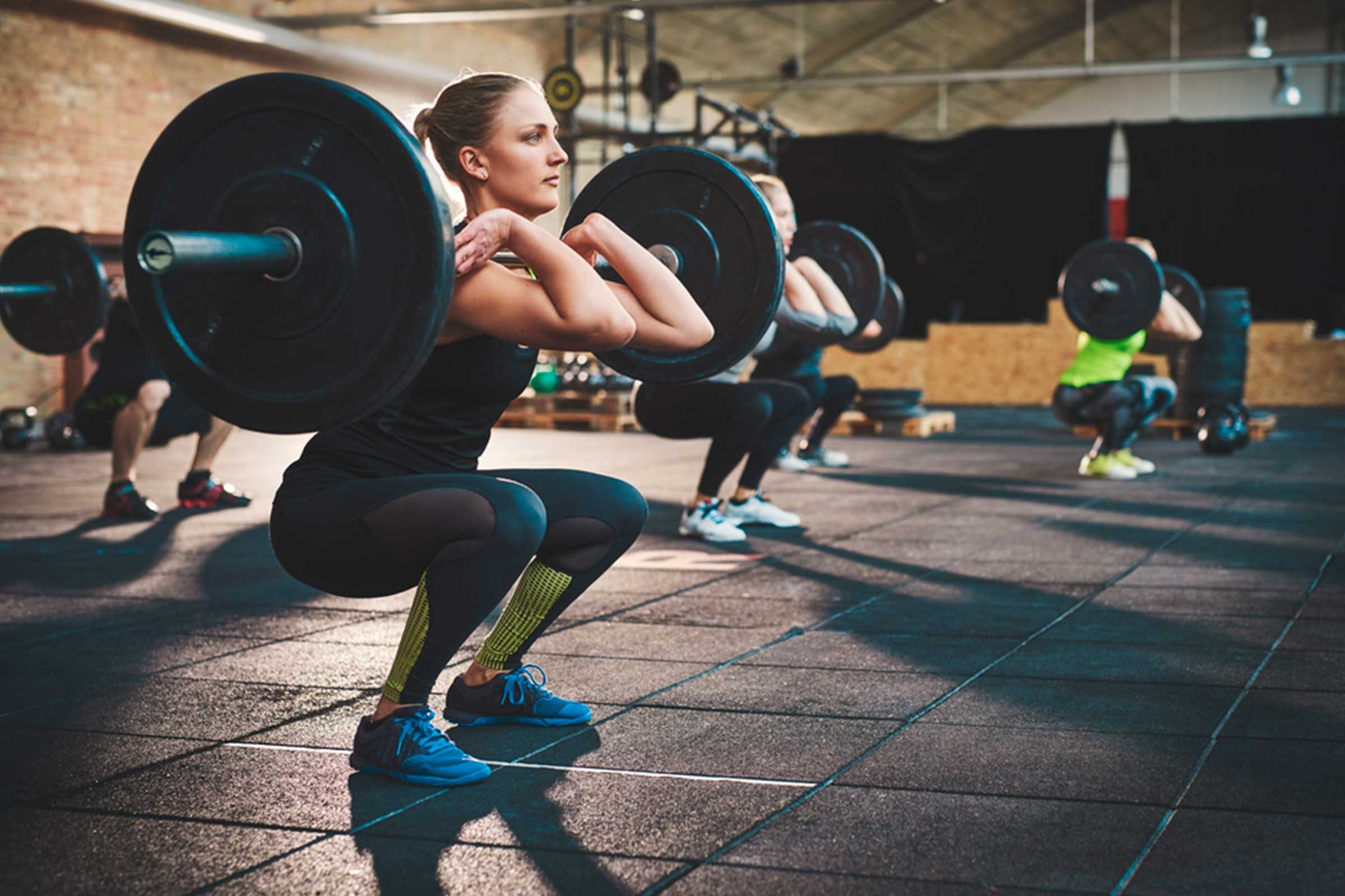 Woman in gym lifting heavy weights