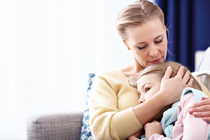 mother holding her sad daughter