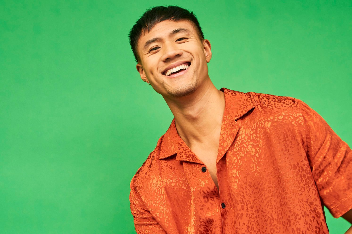 young happy man smiling at camera on green background