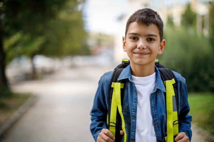 happy young boy walking home from school