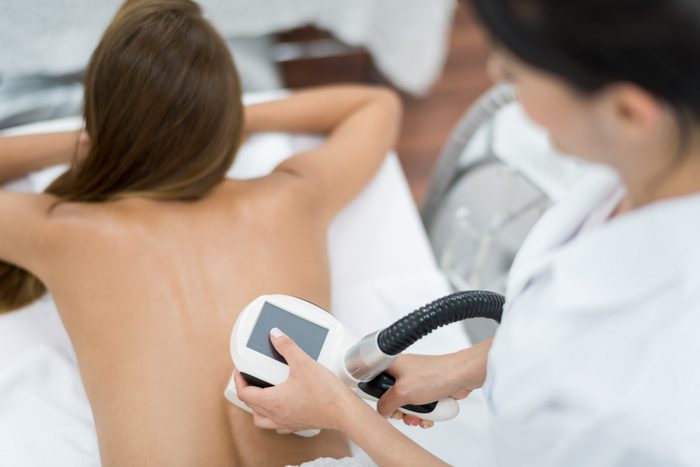 woman getting laser therapy on back