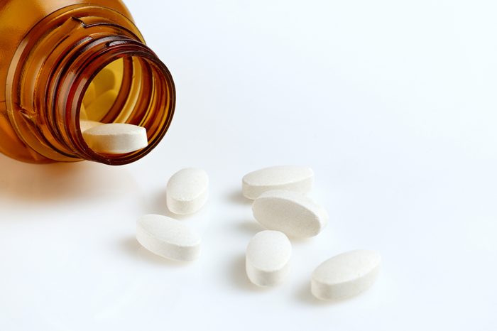 Open bottle that contains pills spilling out of the top.