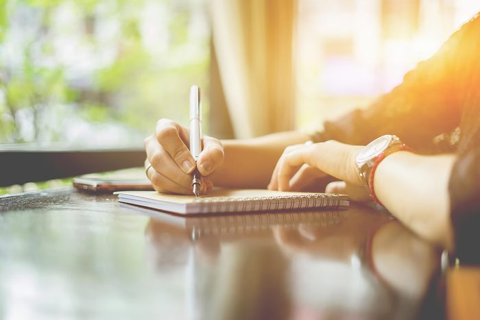 person writing in journal