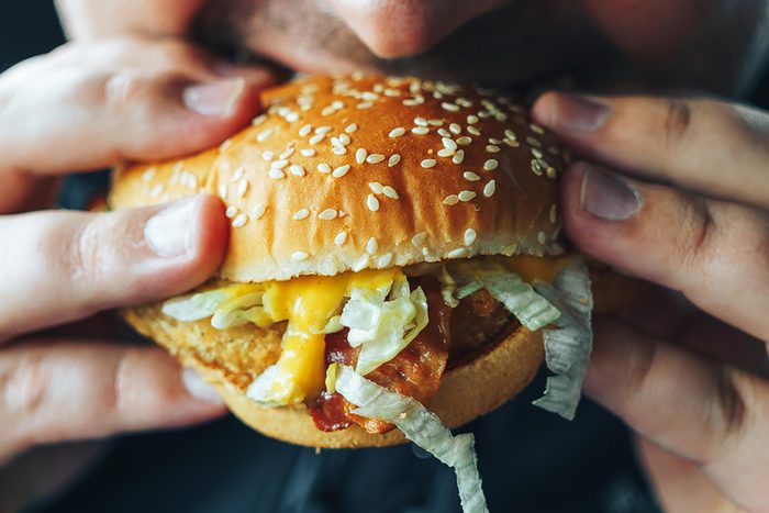 person eating chicken sandwich