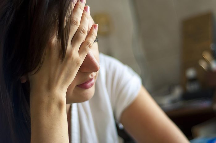 sad woman holding her head in her hands