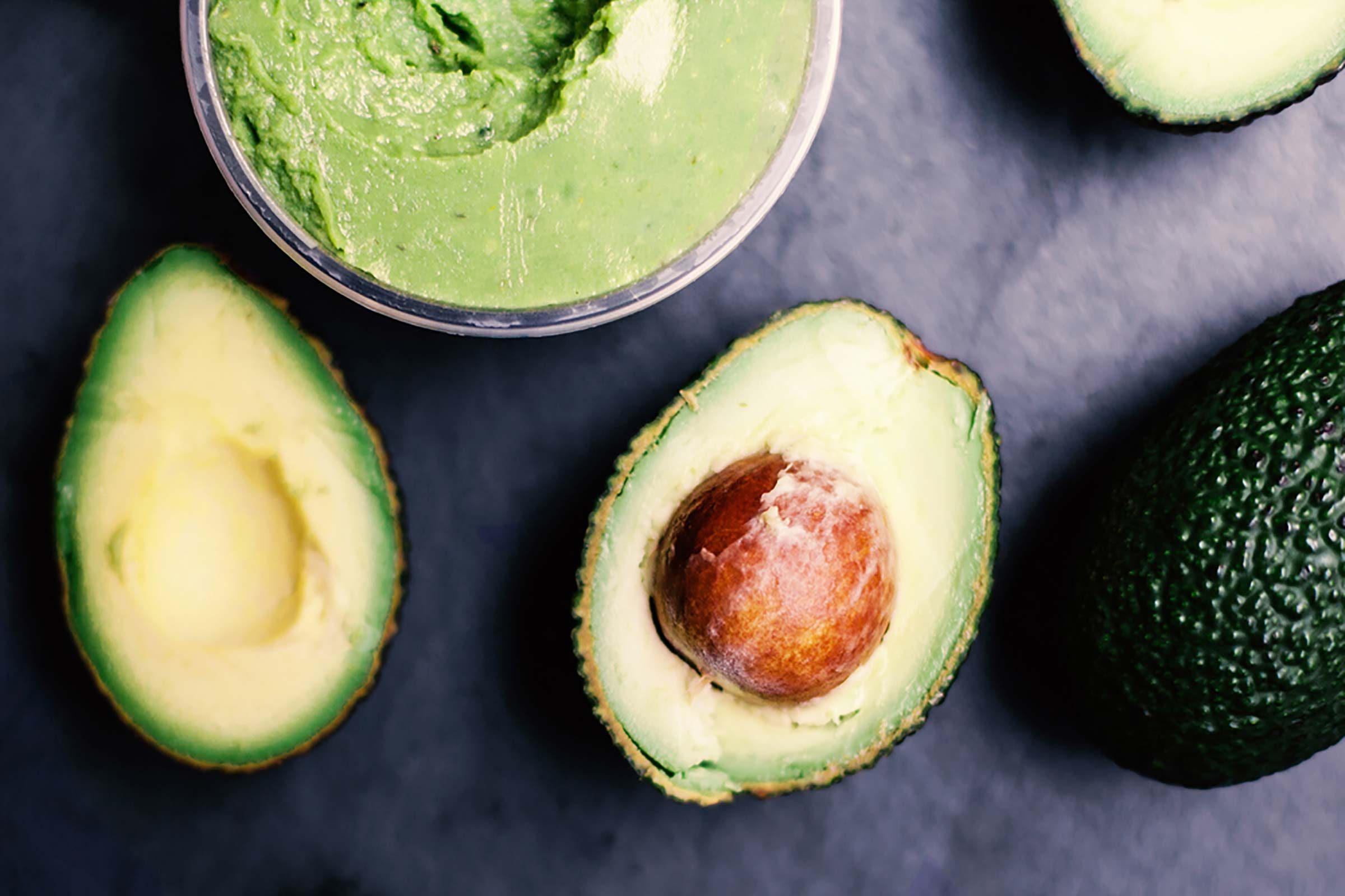 Avocado dip and whole avocados.