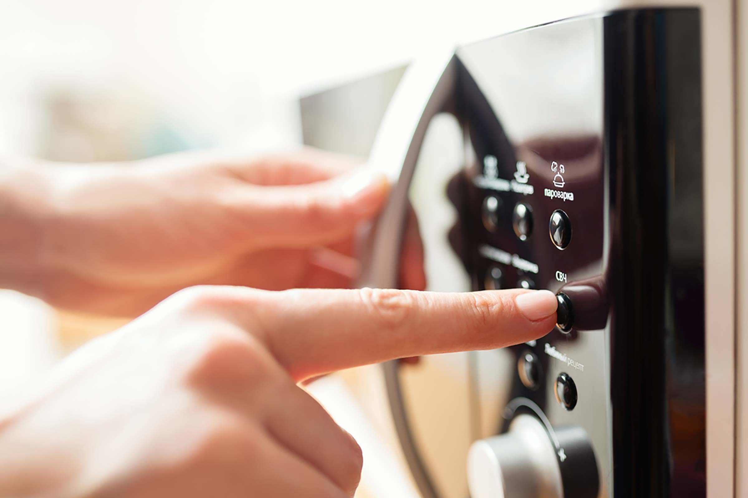 Person pushing microwave buttons.