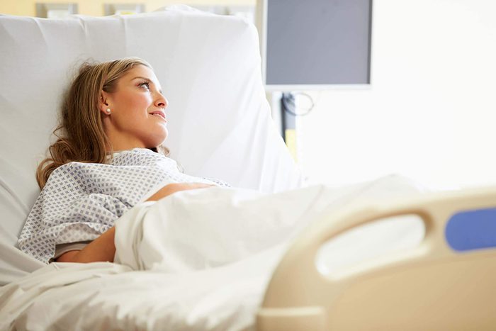 Woman lying in a hospital bed.