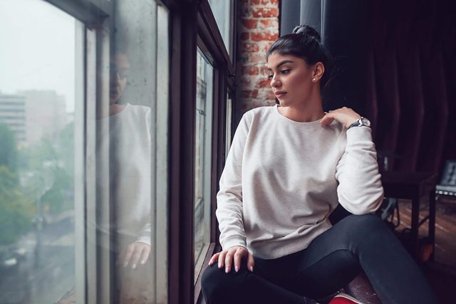 thoughtful woman looking out window