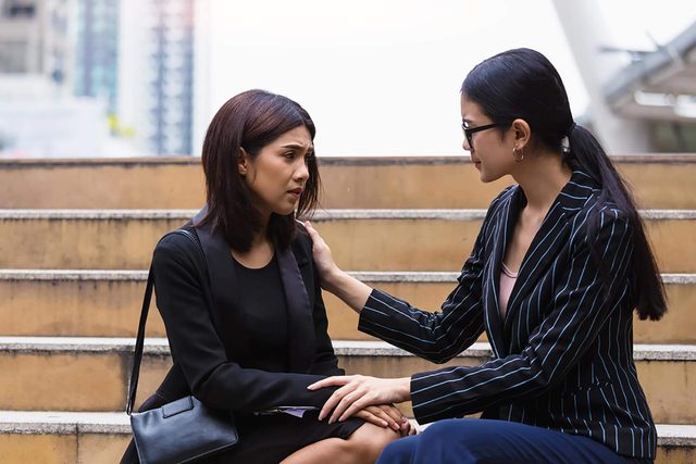 woman comforting another woman