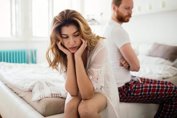 unhappy couple sitting on bed