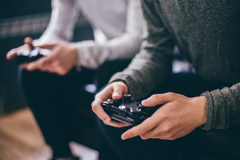 hands holding video game controllers