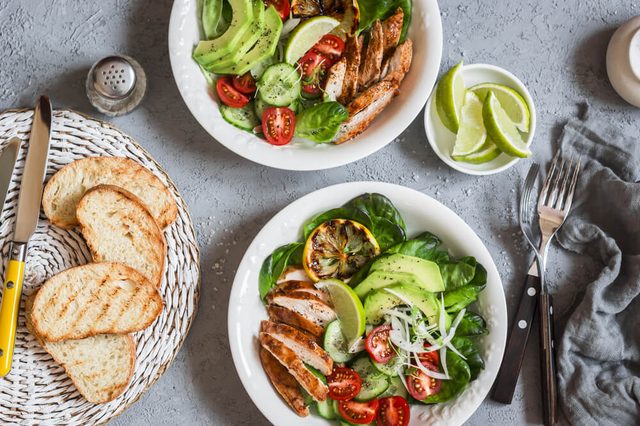 Grilled chicken and fresh vegetable salad. Healthy diet food concept. On a light background, top view.