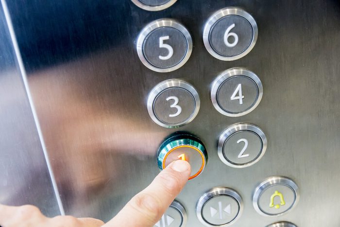 finger pressing elevator button