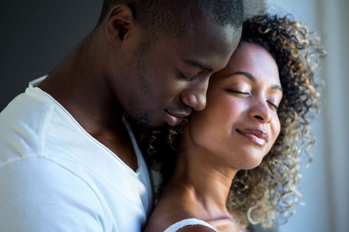Young couple embracing together at home