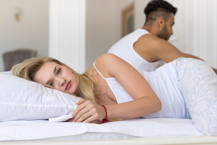 Young Couple Lying In Bed, Having Conflict Problem, Sad Negative Emotions Hispanic Man And Woman Lovers In Bedroom