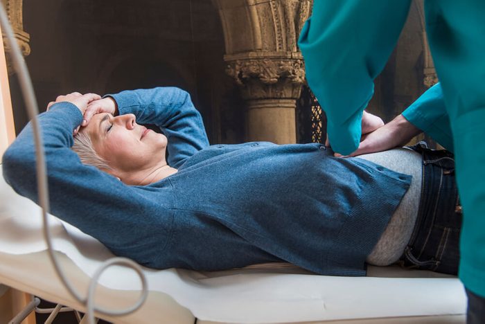 Doctor pressing his patient's stomach, checking the area of pain