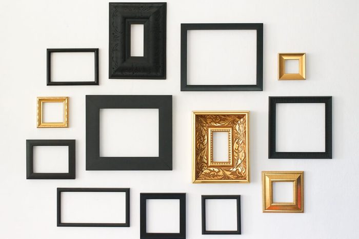 Multiple many blank small picture frames on white wall