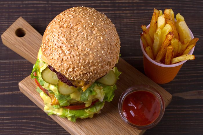 Triple decker burger and fries with a small bowl of ketchup