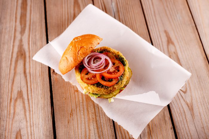 Grilled hamburger with beef, cheese and egg, tomatoes and fried bacon