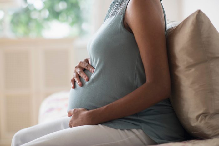 cropped close up shot of pregnant woman holding her stomach