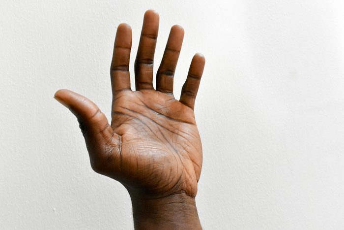 left hand of dark skin man isolated on white background