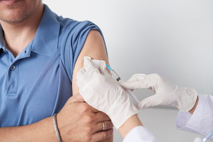 close up cropped shot of doctor giving man a vaccine