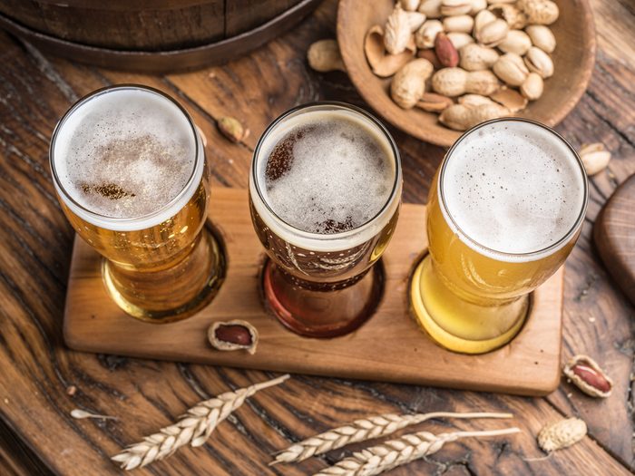 Glasses of beer and snacks on the wooden table. Top view.