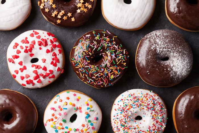 Colorful donuts on stone table. Top view