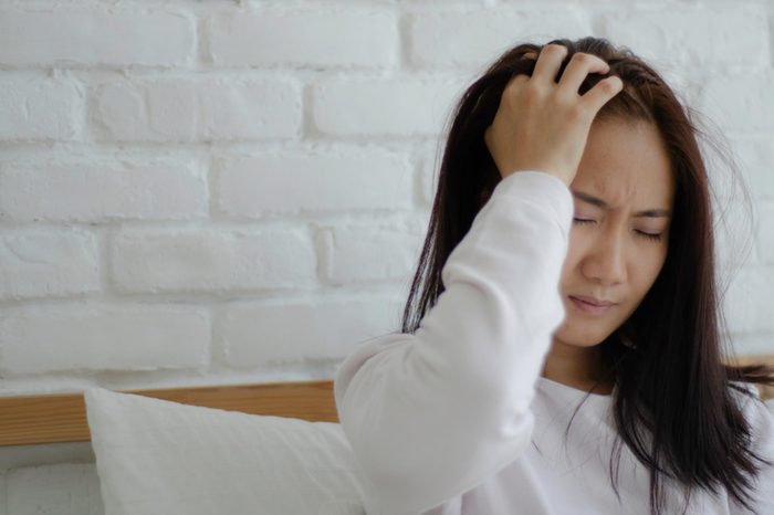 woman holding her head in pain