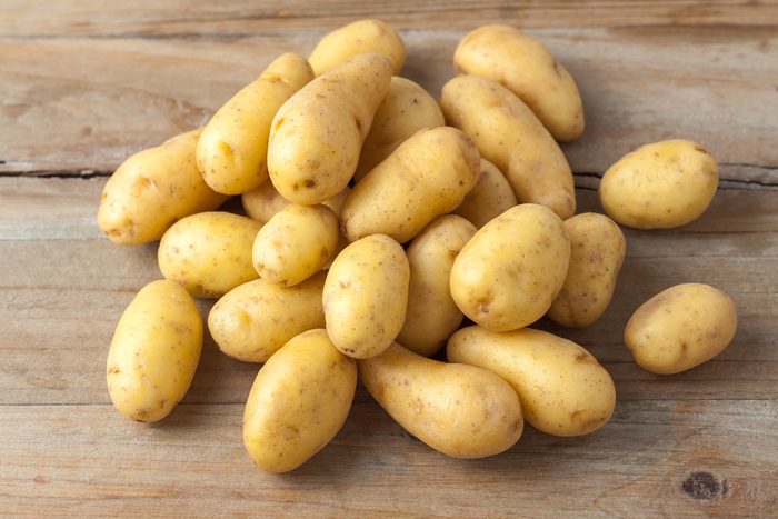 raw baby potatoes on rustic wooden background