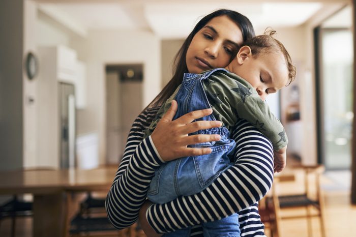 child sleeping in woman's arms