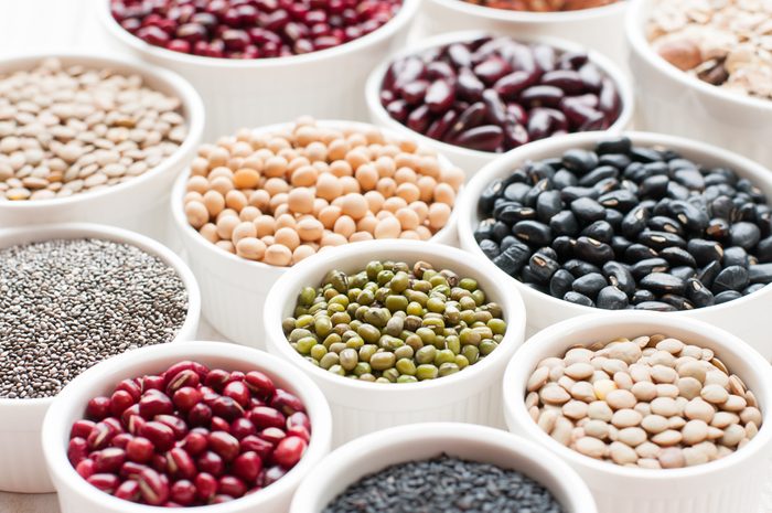 collection set of beans, legumes, peas, lentils on ceramic bowl on white wooden background
