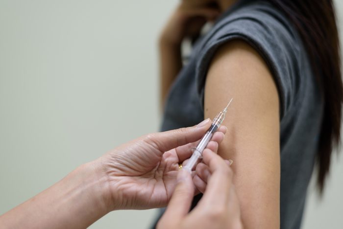 Close up doctor's hand injecting for vaccination in the shoulder woman patient.Vaccine for protection concept.