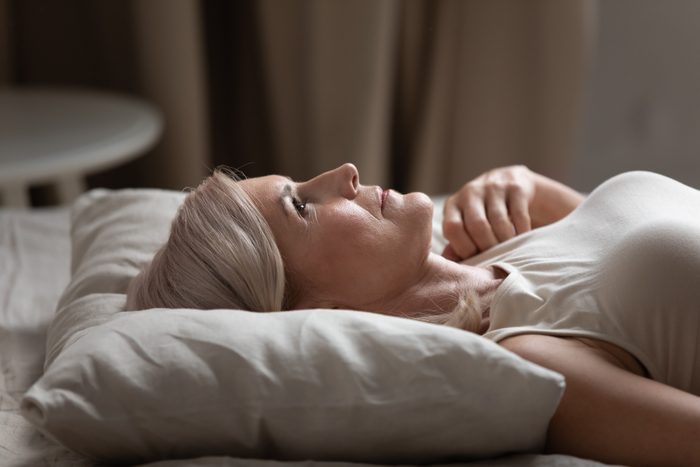 older woman laying awake in bed