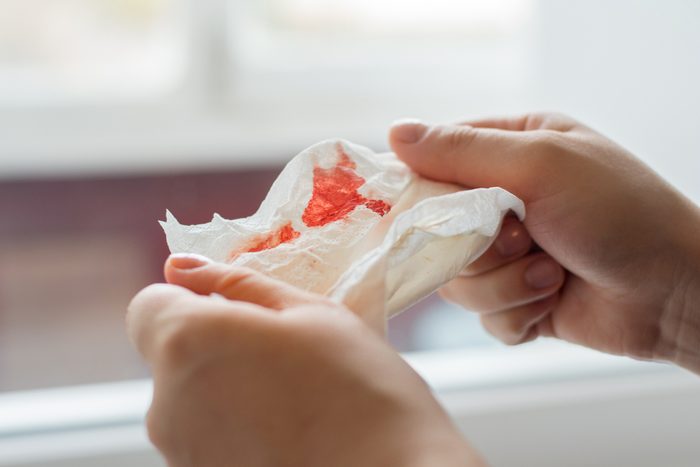 hands holding a bloody tissue